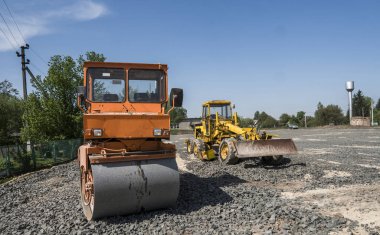 Turuncu ışık titreşim silindir kompaktör duran bir taş yol yapım ve tamir asfalt kaplama mavi gökyüzü ile çalışır.