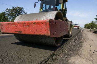 Asfalt kaplama yeni yol inşaat site üzerinde çalışan, ağır titreşim silindir. Onarma.
