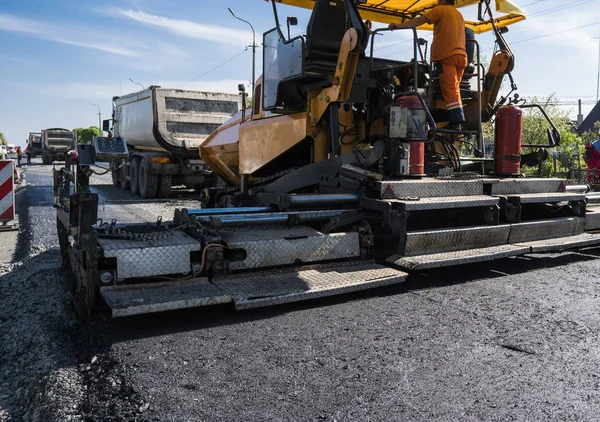 Arbetaren löpande asfalt paver maskin under vägbyggen och reparera verk. Paver efterbehandlare, asfalt Slutbehandlare eller att placera ett lager av asfalt läggare. Återbeläggning — Stockfoto