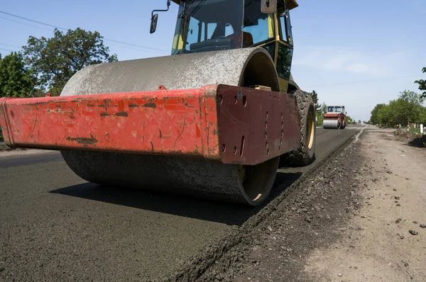 Heavy Vibration roller at asphalt pavement working on the new road construction site. Repairing.