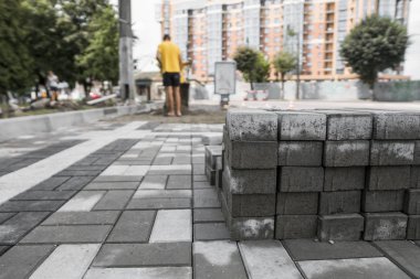 kaldırım Arnavut kaldırımlı sokakta yığınındaki. Beton veya granit gri kare kaldırım döşeme kaldırım yapımı için. Sanayi üretim veya kavram bina. İnşaat malzemesi.
