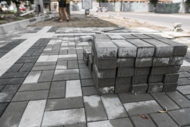 kaldırım Arnavut kaldırımlı sokakta yığınındaki. Beton veya granit gri kare kaldırım döşeme kaldırım yapımı için. Sanayi üretim veya kavram bina. İnşaat malzemesi.