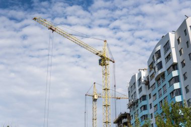 Vinç ve bina inşaat mavi bulutlu gökyüzü altında.