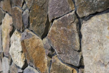 Doğal taş çit yüzeyine yakın çekim. Taş duvar arka plan olarak.