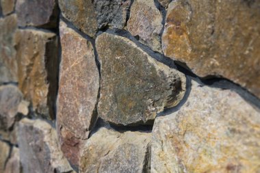 Doğal taş çit yüzeyine yakın çekim. Taş duvar arka plan olarak.