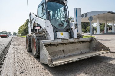 Asfalt Finişer makine yol yapım ve onarım işleri sırasında. Bir fayans ustası son işlemci, asfalt tamamlayıcı veya kaldırım makine asfalt tabakası yerleştirerek. Asfaltlanması.