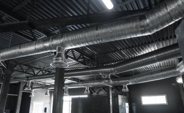 Büyük binaların tavanındaki havalandırma sistemi. Yeni binanın tavanından sarkan gümüş yalıtım malzemelerindeki havalandırma boruları..