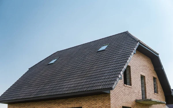 Natuurlijke bruine dakpannen op een gebouw tegen blauwe hemel. — Stockfoto