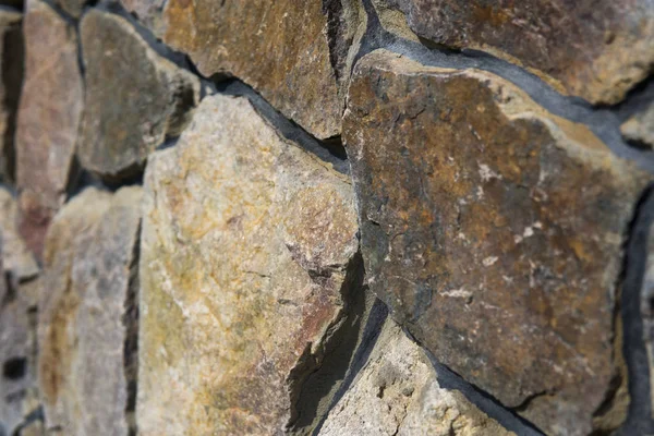 Doğal taş çit yüzeyine yakın çekim. Taş duvar arka plan olarak.