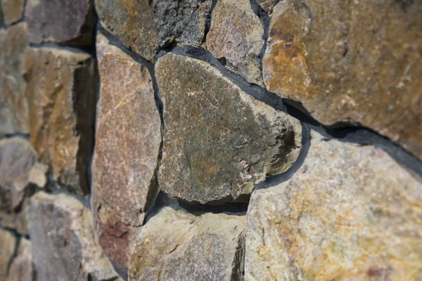 Doğal taş çit yüzeyine yakın çekim. Taş duvar arka plan olarak.