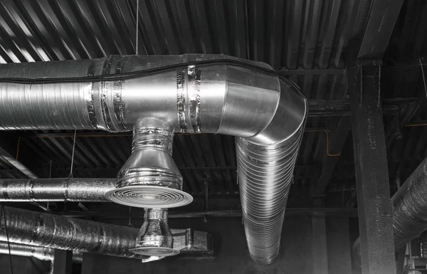 Büyük binaların tavanındaki havalandırma sistemi. Yeni binanın tavanından sarkan gümüş yalıtım malzemelerindeki havalandırma boruları.