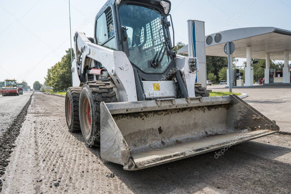 Asphalt paver machine during road construction and repairing works. A paver finisher, asphalt finisher or paving machine placing a layer of asphalt. Repaving.