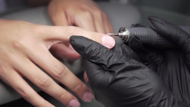 Pédicure matérielle professionnelle utilisant une machine électrique. La manucure broie les ongles de la fille dans le salon de manucure et leur donne maintenant une forme. Patient en pédicure médicale . — Video