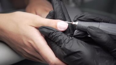 Profesyonel donanım Pedikür elektrik makine kullanarak. Öğütülmüş manikürcü kız tırnak salonu içinde çivi ve şimdi onları bir form verir. Hastanın tıbbi pedikür usulü hakkında.