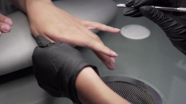 Profesyonel donanım Pedikür elektrik makine kullanarak. Öğütülmüş manikürcü kız tırnak salonu içinde çivi ve şimdi onları bir form verir. Hastanın tıbbi pedikür usulü hakkında.