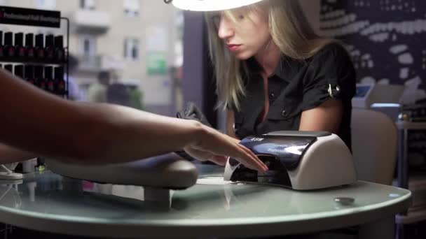 Vrouw met een nail manicure in een schoonheidssalon met een close-up beeld van een vernis toe te passen met een applicator schoonheidsspecialiste. — Stockvideo