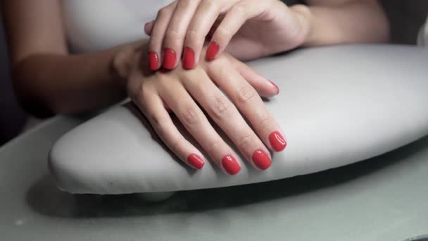 Beautiful female hands with red nails in beauty nail salon. Beautiful female nails and manicure. — Stock Video