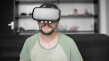 Genç sakallı 360 video ve bir duygu olarak o bir konser izlemek için onun Vr kulaklık görüntü kullanılarak hipster adam ya da evde oturma odasında kanepede otururken disko. VR teknolojisi
