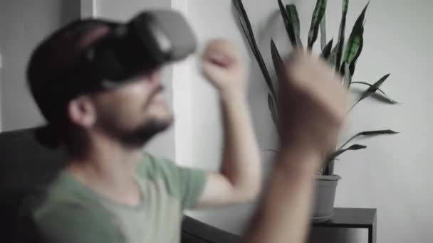Junger bärtiger Hipstermann mit seinem vr-Headset-Display, um das 360-Video anzusehen und fühlt sich wie auf einem Konzert oder in einer Disco, während er zu Hause auf dem Sofa im Wohnzimmer sitzt. vr-Technologie. — Stockvideo