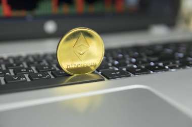 Ethereum altın sikke gümüş laptop ve diyagram grafik grafik arka plan olarak bir ekran üzerinde siyah bir klavye üzerinde. Sanal cryptocurrency kavramı. Ethereums online iş araştırma. Ticaret.