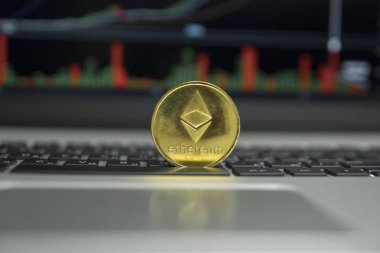 Ethereum altın sikke gümüş laptop ve diyagram grafik grafik arka plan olarak bir ekran üzerinde siyah bir klavye üzerinde. Sanal cryptocurrency kavramı. Ethereums online iş araştırma. Ticaret.