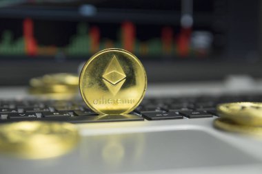 Altın Ethereum madeni para ile altın gümüş laptop ve diyagram grafik grafik arka plan olarak bir ekranda siyah klavyesindeki etrafında yalan. Ethereums online iş araştırma. Ticaret.