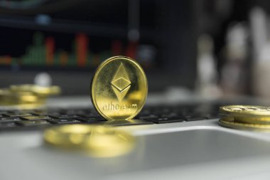 Altın Ethereum madeni para ile altın gümüş laptop ve diyagram grafik grafik arka plan olarak bir ekranda siyah klavyesindeki etrafında yalan. Ethereums online iş araştırma. Ticaret.