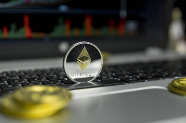 Altın Gümüş Ethereum madeni para ile altın gümüş laptop ve diyagram grafik grafik arka plan olarak bir ekranda siyah klavyesindeki etrafında yalan. Ethereums online iş araştırma. Ticaret.
