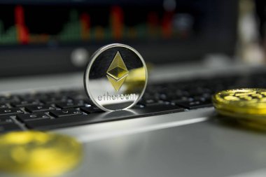 Altın Gümüş Ethereum madeni para ile altın gümüş laptop ve diyagram grafik grafik arka plan olarak bir ekranda siyah klavyesindeki etrafında yalan. Ethereums online iş araştırma. Ticaret.