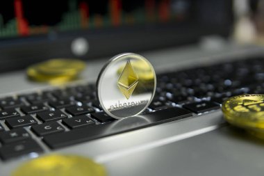 Altın Gümüş Ethereum madeni para ile altın gümüş laptop ve diyagram grafik grafik arka plan olarak bir ekranda siyah klavyesindeki etrafında yalan. Ethereums online iş araştırma. Ticaret.