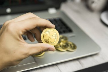 Laptop klavye ve altın sikke yığını bir arka plan dalgalanma para tutan erkek işadamı el. Sanal para ve finansal büyüme kavramı. Of Ripples ticaret madencilik.