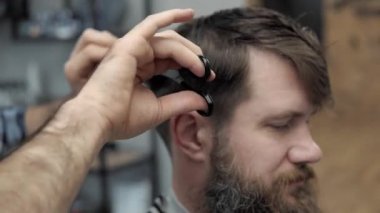 Close-up Kuaför, berber makas tarafından saç keser. Çalışma süreci salonların ellere. Berber dükkanı çekici sakallı adamın yapma saç kesimi berber. Kuaför iş başında. Güzellik Salonu.