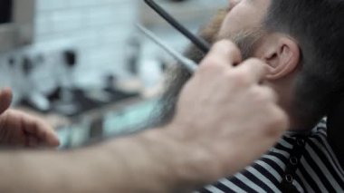 Yapıyor Kuaför saç kesimi ile yetişkin erkekler erkek kuaför salonu içinde uzun sakallı sakallar. Sakal bakım. Salonların işyerinde. Sakal saç şekillendirme ve kanununu bir kuaför dükkanında.