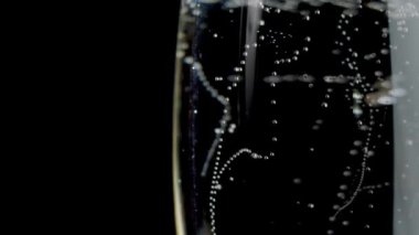 köpüklü beyaz şarap. Beyaz şarap bir bardak siyah arka plan dökülür varlık. Ağır çekim. Fragolino. Beyaz şarap