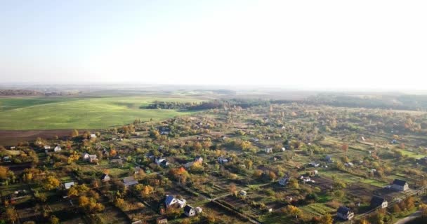 Vista aérea do campo de verão com campos agrícolas e casas. Céu azul ensolarado. Área agrícola no campo com casas e telhados de construção. Visão dos olhos das aves nos campos agrícolas . — Vídeo de Stock