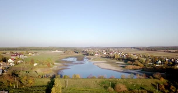 Aerial view of summer countryside with agricultural fields and houses. Farmland area in countryside with houses and building roofs. Birds eye view on agriculture fields. — Stock Video