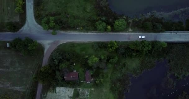 Auto fährt auf der Abendstraße außerhalb der Stadt. die Brücke über den Fluss. Luftflug über Landstraße, die durch den Fluss führt. — Stockvideo
