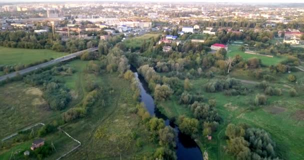 Luchtfoto van zomer landschap met landbouwgronden en huizen. Gebied van de landbouwgrond in landschap met huizen en daken van het gebouw. Vogels oog uitzicht op landbouw velden. — Stockvideo