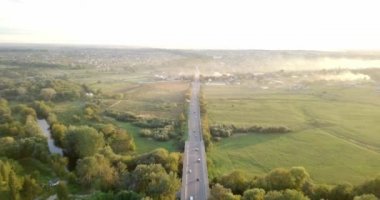 Havadan görünümü bir kamyon ve diğer trafik güneş doğarken bir yol sürüş. Güzel gün batımı Rating ve uzun nehir dolu yol üzerinde. Büyük gökyüzü. Güzel sonbahar doğa. Renkli doğa