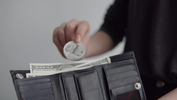 Kvinnor hand sätta en silver bitcoin och litecoin mynt i hans plånbok. Världsomspännande kryptovaluta och digitala betalningssystem. Begreppet tjänar krypto valuta. Resultat från gruvdrift crypto. — Stockvideo
