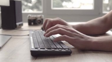 Genç bir klavyede yazarak ve sonra da cep telefonu akıllı telefon kullanarak ve bir haberci yazarak adam. Çalışma ve istemcileriyle iletişim için tablet kullanarak serbest fotoğrafçı.