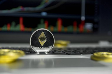 Altın Gümüş Ethereum madeni para ile altın gümüş laptop ve diyagram grafik grafik arka plan olarak bir ekranda siyah klavyesindeki etrafında yalan. Ethereums online iş araştırma. Ticaret.