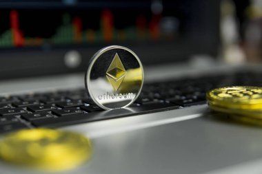 Altın Gümüş Ethereum madeni para ile altın gümüş laptop ve diyagram grafik grafik arka plan olarak bir ekranda siyah klavyesindeki etrafında yalan. Ethereums online iş araştırma. Ticaret.