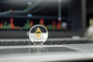 Ethereum altın gümüş sikke gümüş laptop ve diyagram grafik grafik arka plan olarak bir ekran üzerinde siyah bir klavye üzerinde. Sanal cryptocurrency kavramı. Ethereums online iş araştırma. Ticaret.