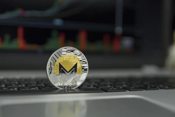 Moneda de oro y plata de Monero en un teclado negro de la computadora portátil de plata y diagrama gráfico en una pantalla como fondo. Concepto criptomoneda. Minería de etéreos negocio en línea. Operaciones . — Foto de Stock