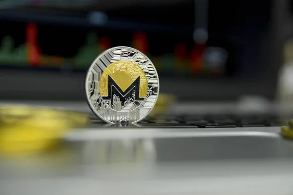 Moneda de oro Monero con monedas de oro en torno a un teclado negro de la computadora portátil de plata y diagrama gráfico en una pantalla como fondo. Minería de Moneros negocio en línea. Operaciones . — Foto de Stock