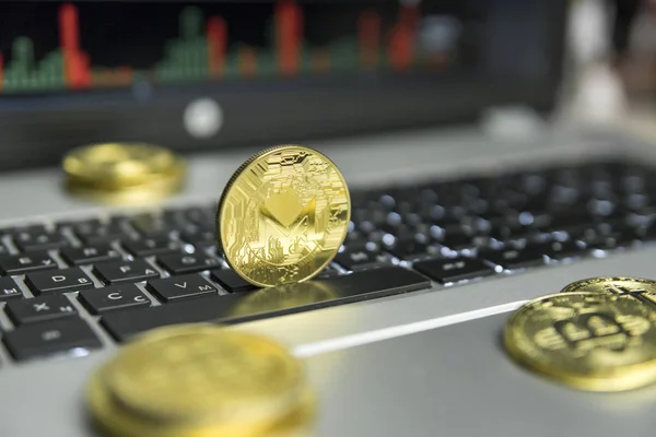 ゴールド コインと銀のラップトップとダイアグラム チャート背景として画面上の黒いキーボードで転がって黄金 Monero コイン。Moneros オンライン事業の採掘。取引. — ストック写真