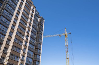 Yüksek katlı bir vinç ile bina inşaatı. Bina inşaat kalıp kullanarak. Vinçler ve mavi gökyüzü karşı binaları.