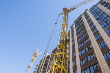 Yüksek katlı bir vinç ile bina inşaatı. Bina inşaat kalıp kullanarak. Vinçler ve mavi gökyüzü karşı binaları.