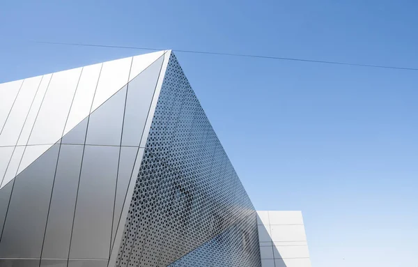 Edificio con fachada de aluminio blanco y paneles de aluminio contra cielo azul . — Foto de Stock